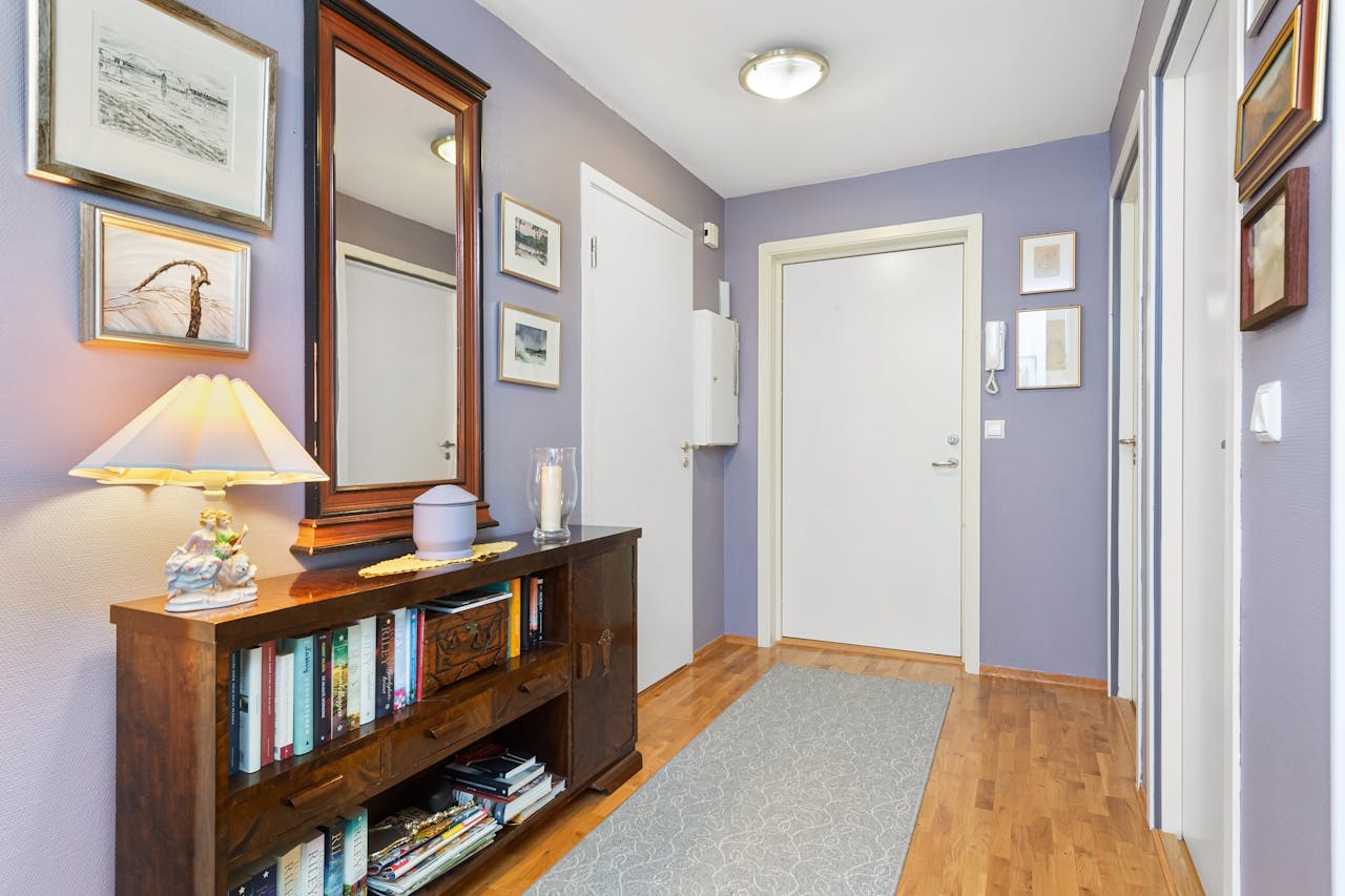 Inviting hallway space with purple walls, wooden bookcase, and elegant decor.